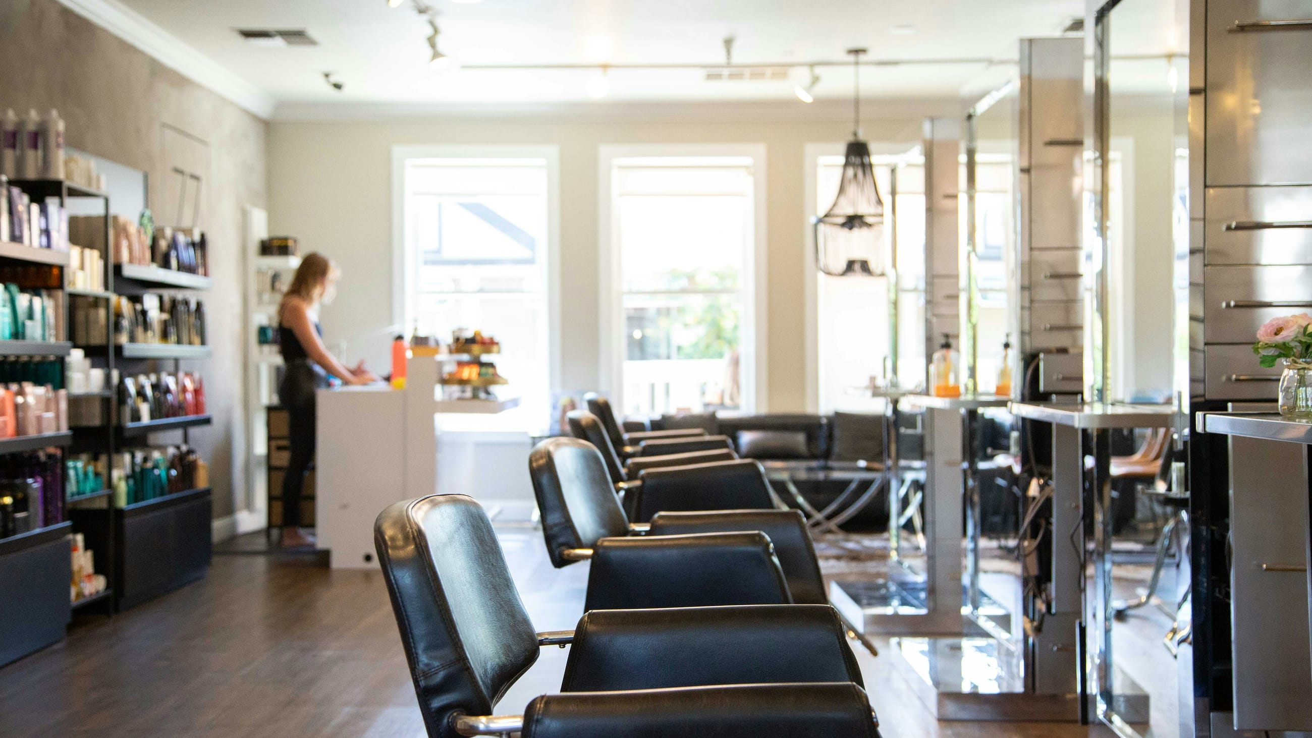 Client seated at the salon mirror, hair freshly cut and styled, smiling at her reflection
