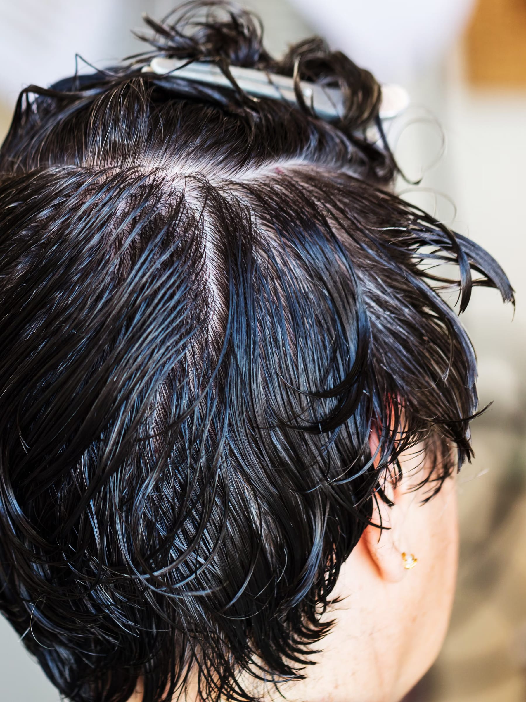 Stylist cutting soft layers into a client's mid-length hair