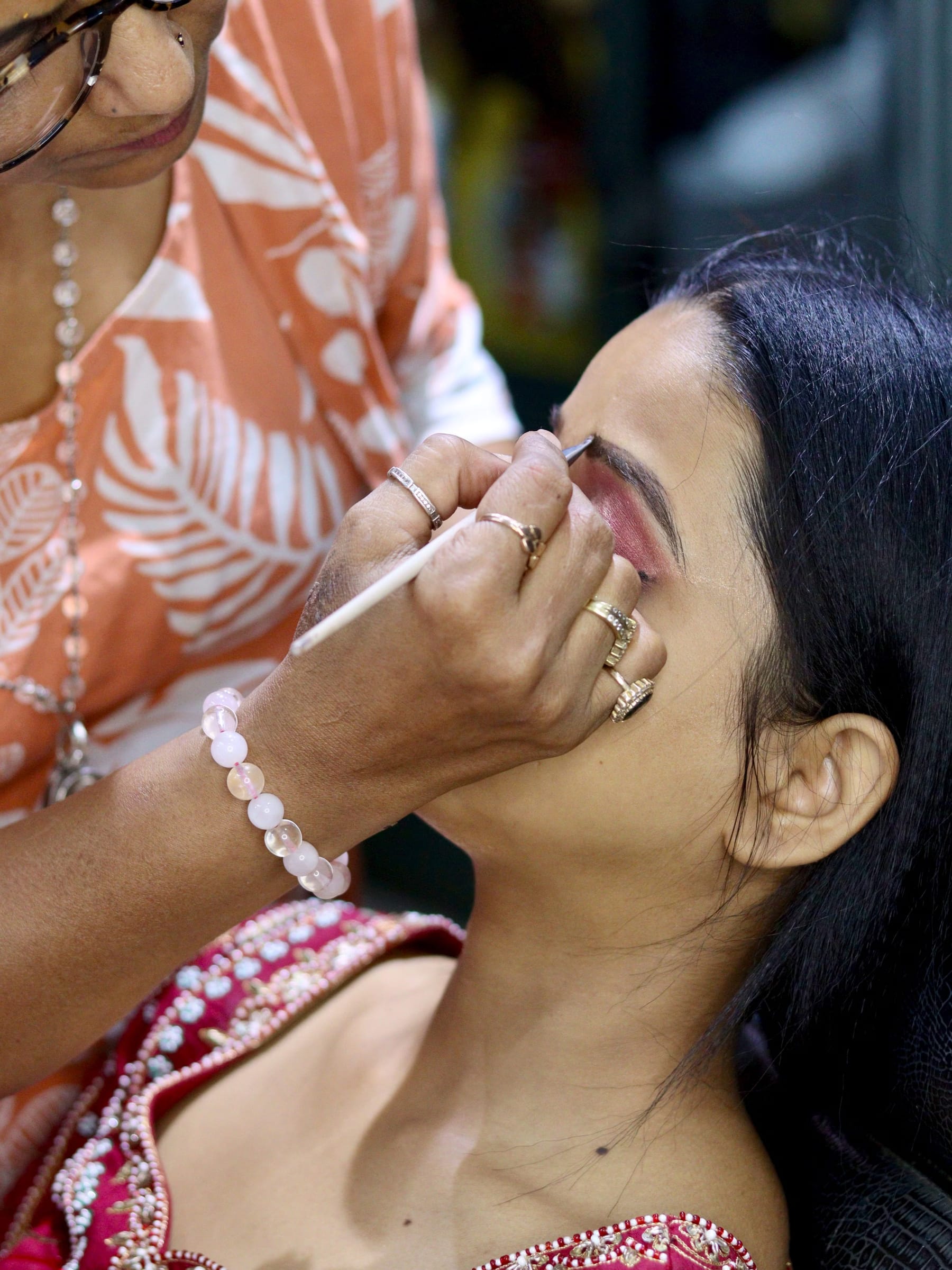 Makeup artist setting a bride's eye makeup with a fine brush